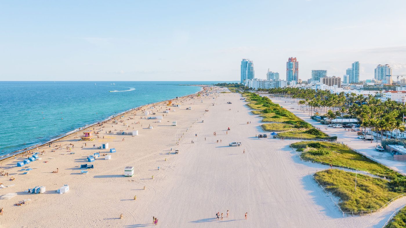 Wide South Beach shoreline with lifeguard tower and the Miami skyline behind it